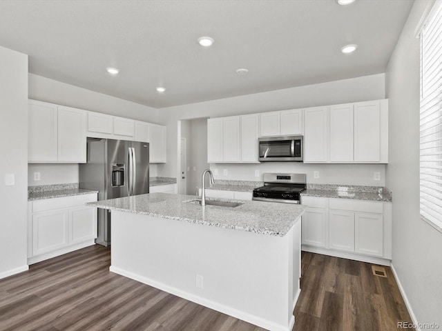 1023 Odessa Lake Rd, Severance, CO 80550 - kitchen featuring stainless steel appliances, dark wood finished floors, white cabinetry, a kitchen island with sink, and recessed lighting