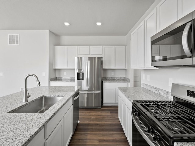 1023 Odessa Lake Rd, Severance, CO 80550 - kitchen featuring appliances with stainless steel finishes, recessed lighting, light stone countertops, white cabinets, and dark wood-style flooring