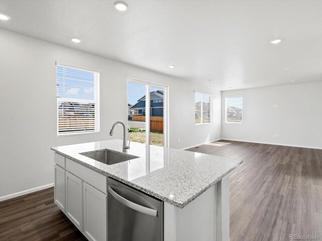 1023 Odessa Lake Rd, Severance, CO 80550 - kitchen with dishwasher, dark wood finished floors, a kitchen island with sink, recessed lighting, and white cabinetry