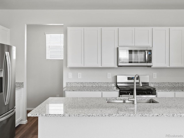 1023 Odessa Lake Rd, Severance, CO 80550 - kitchen with appliances with stainless steel finishes, white cabinetry, and light stone counters