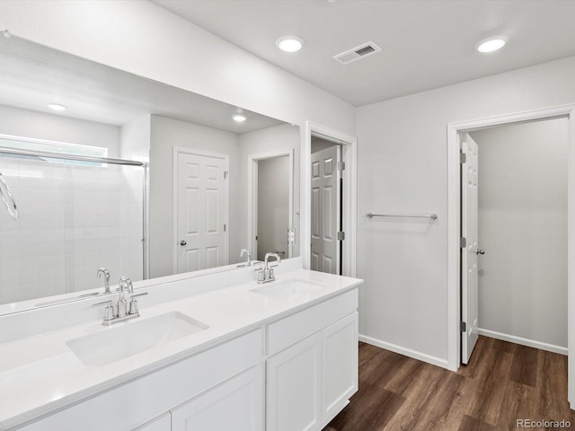 1023 Odessa Lake Rd, Severance, CO 80550 - bathroom featuring wood finished floors, a stall shower, double vanity, and recessed lighting