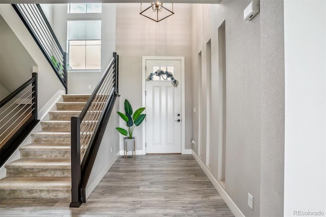 8299 S Kellerman, Aurora, CO 80016 - entryway featuring a high ceiling, stairway, wood finished floors, a chandelier, and baseboards