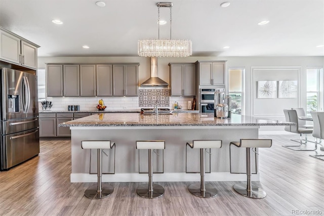 8299 S Kellerman, Aurora, CO 80016 - kitchen featuring stainless steel appliances, wall chimney range hood, gray cabinetry, a kitchen breakfast bar, and recessed lighting