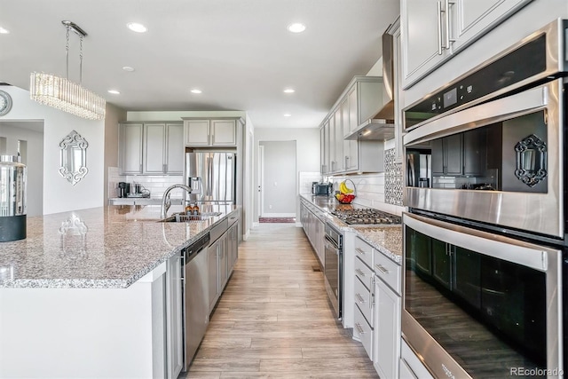 8299 S Kellerman, Aurora, CO 80016 - kitchen featuring stainless steel appliances, a sink, recessed lighting, light wood-type flooring, and backsplash