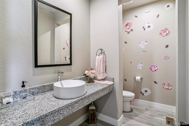 8299 S Kellerman, Aurora, CO 80016 - bathroom featuring a sink, toilet, wood finished floors, and baseboards