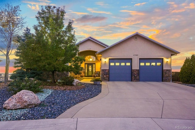 1743 Homestead Dr, Fort Lupton, CO 80621 - view of front of home with a garage, stucco siding, driveway, and stone siding