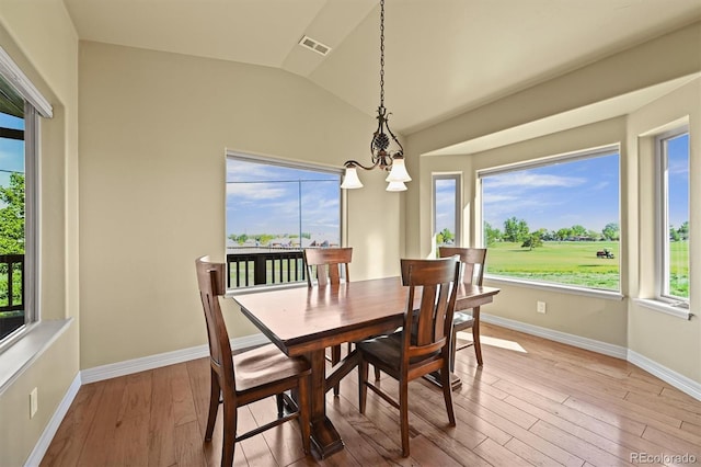 1743 Homestead Dr, Fort Lupton, CO 80621 - dining area featuring healthy amount of natural light, vaulted ceiling, light wood finished floors, baseboards, and a chandelier