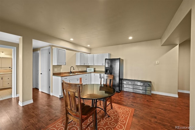 1743 Homestead Dr, Fort Lupton, CO 80621 - kitchen with black fridge with ice dispenser, a sink, white microwave, dark wood-type flooring, and baseboards