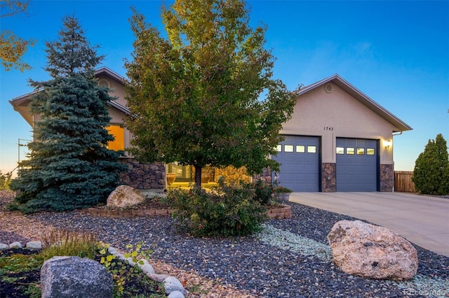 1743 Homestead Dr, Fort Lupton, CO 80621 - view of front of property with driveway, stone siding, stucco siding, and a garage