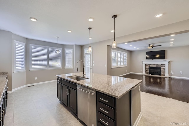 3423 Princeton Pl, Broomfield, CO 80023 - kitchen featuring a sink, dishwasher, a ceiling fan, a fireplace, and light tile patterned flooring