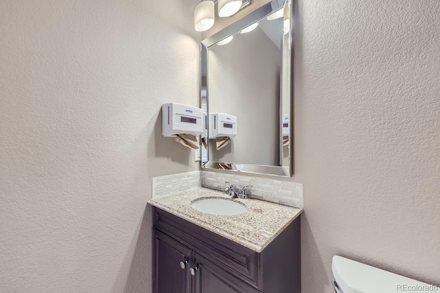 3423 Princeton Pl, Broomfield, CO 80023 - half bathroom featuring backsplash, vanity, toilet, and a textured wall