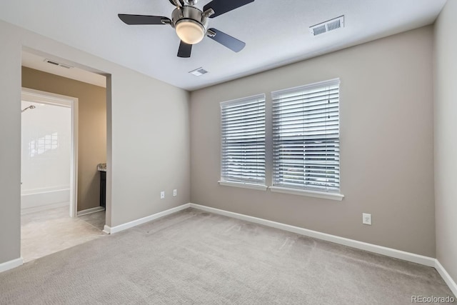 spare room featuring light colored carpet and ceiling fan