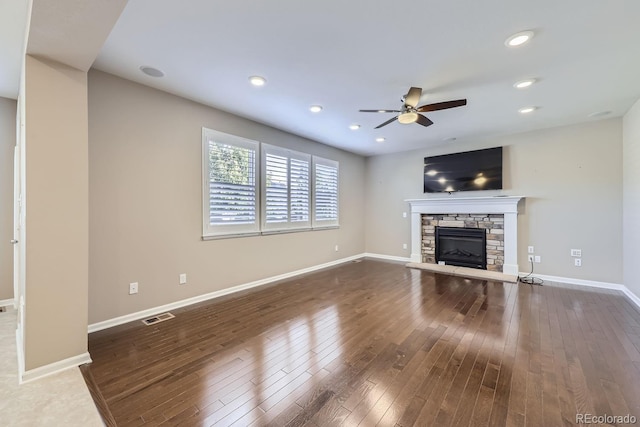 unfurnished living room featuring hardwood / wood-style floors, a fireplace, and ceiling fan