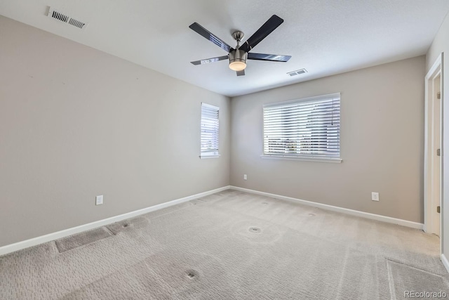 carpeted spare room featuring ceiling fan