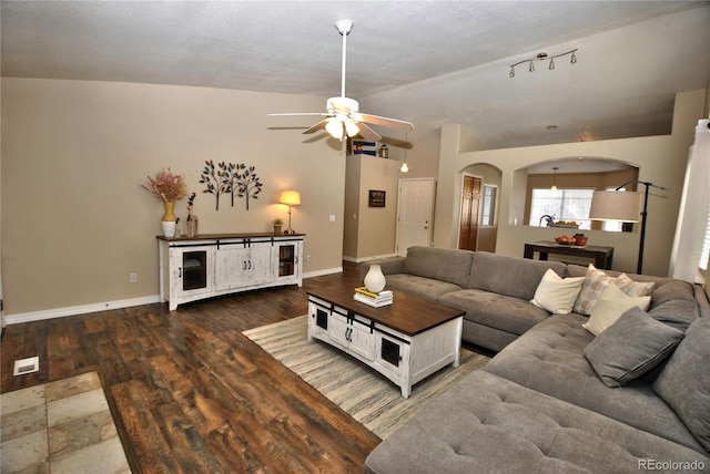 living room featuring ceiling fan, dark hardwood / wood-style flooring, and vaulted ceiling