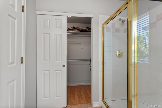 2211 S Moline Ct, Aurora, CO 80014 - bathroom with a stall shower, a spacious closet, and wood finished floors