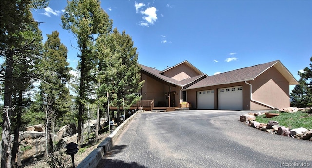 319 Summit Rd, Woodland Park, CO 80863 - view of front of home with a garage, stucco siding, and asphalt driveway