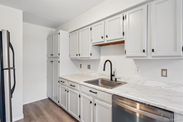 3141 S Tamarac Dr Unit 206E, Denver, CO 80231 - kitchen featuring stainless steel dishwasher, freestanding refrigerator, wood finished floors, and white cabinetry