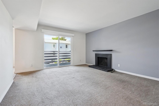3141 S Tamarac Dr Unit 206E, Denver, CO 80231 - unfurnished living room with carpet flooring and a fireplace with raised hearth