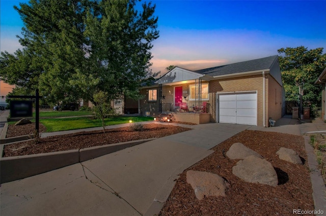 ranch-style home with a garage, brick siding, and driveway