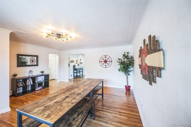 3241 Sheridan Blvd, Wheat Ridge, CO 80212 - dining space featuring arched walkways, wood finished floors, and baseboards