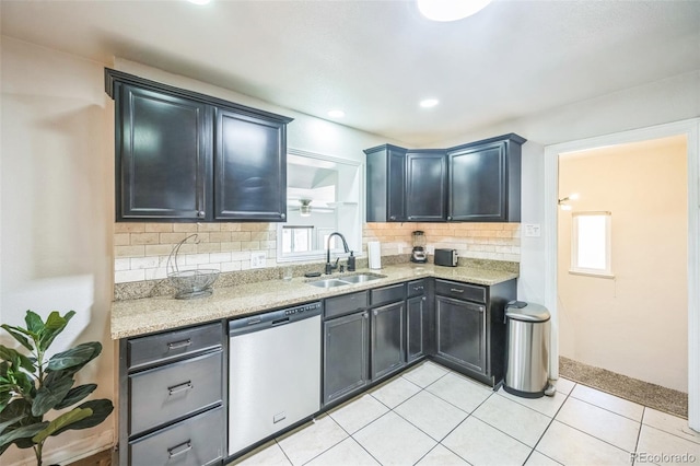 3241 Sheridan Blvd, Wheat Ridge, CO 80212 - kitchen featuring stainless steel dishwasher, a sink, decorative backsplash, light tile patterned floors, and light stone countertops