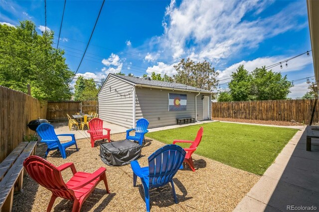 3241 Sheridan Blvd, Wheat Ridge, CO 80212 - view of yard with an outdoor fire pit, an outdoor structure, and a patio