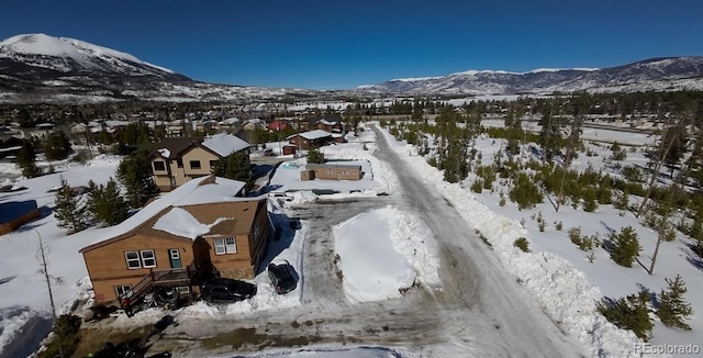 snowy aerial view with a residential view and a mountain view