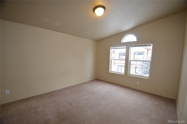 empty room featuring light carpet and lofted ceiling