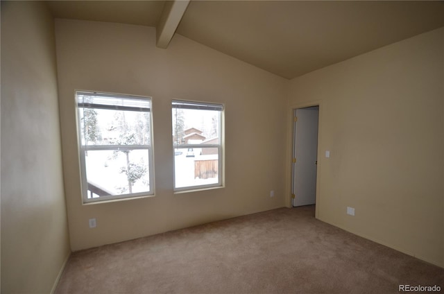 spare room featuring carpet floors and lofted ceiling with beams