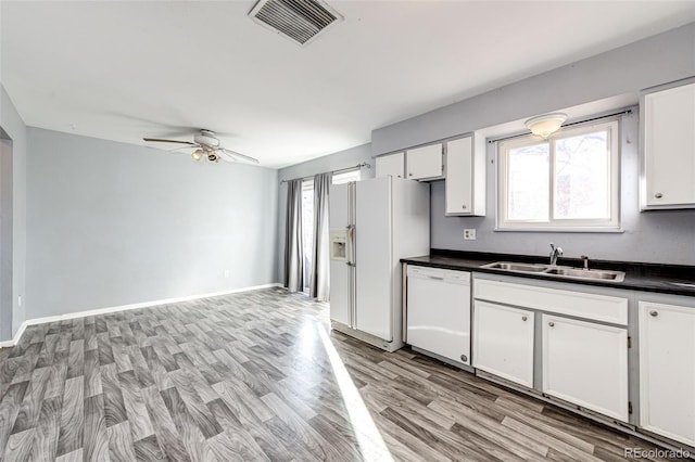 kitchen featuring white cabinets, white appliances, light hardwood / wood-style flooring, and sink