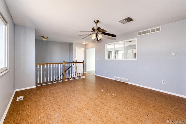 spare room with ceiling fan, wood-type flooring, and a wealth of natural light