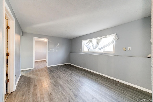 unfurnished room with dark hardwood / wood-style flooring