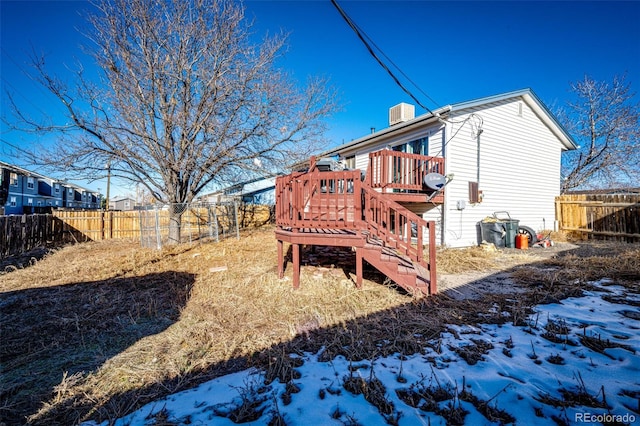 snow covered house with a wooden deck