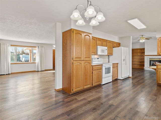 kitchen featuring white appliances, dark wood-type flooring, ceiling fan with notable chandelier, hanging light fixtures, and a fireplace