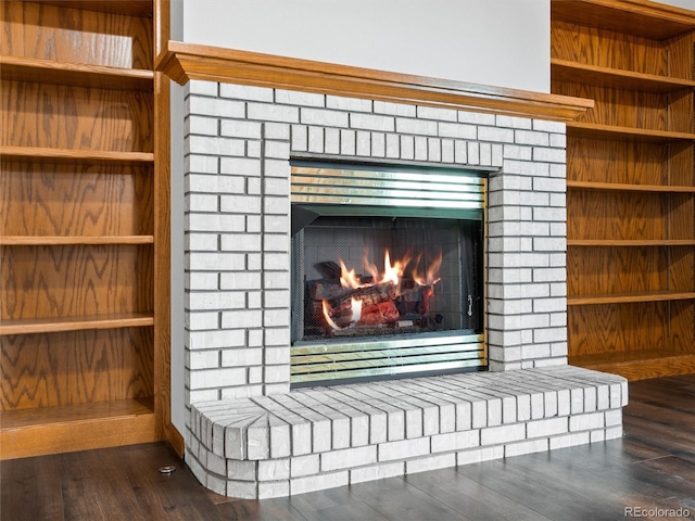 interior details with hardwood / wood-style floors and a brick fireplace