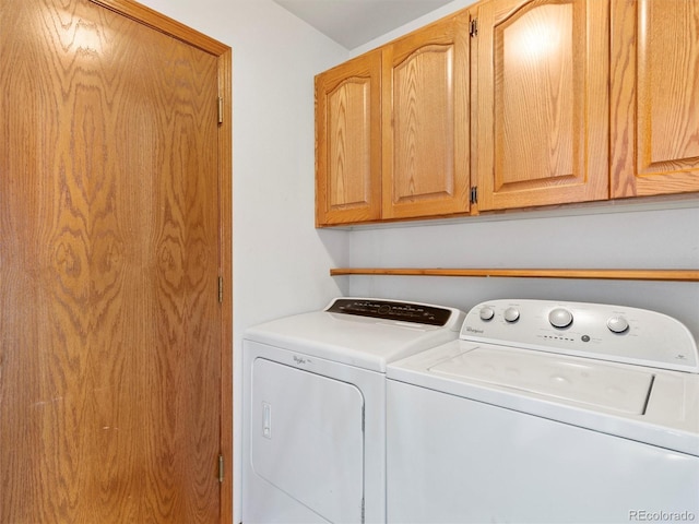 laundry room featuring washing machine and dryer and cabinets