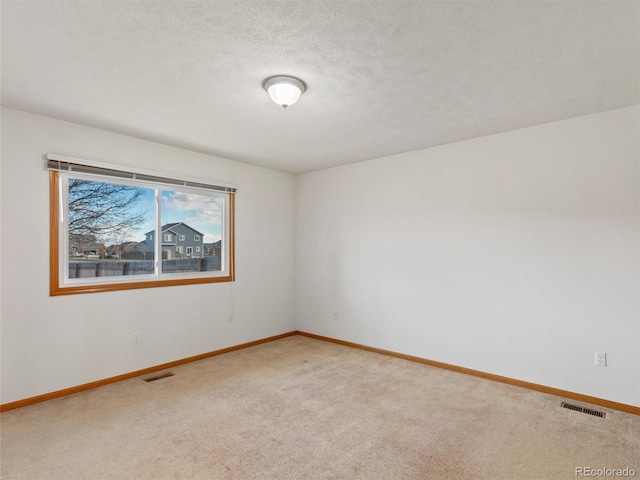 carpeted empty room with a textured ceiling