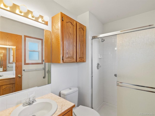 bathroom with vanity, toilet, and a shower with shower door