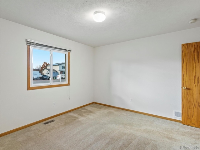 spare room with carpet and a textured ceiling