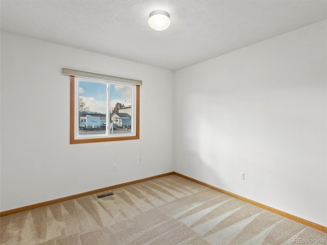 carpeted spare room with a textured ceiling