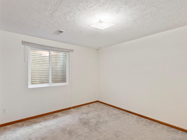 carpeted empty room with a textured ceiling