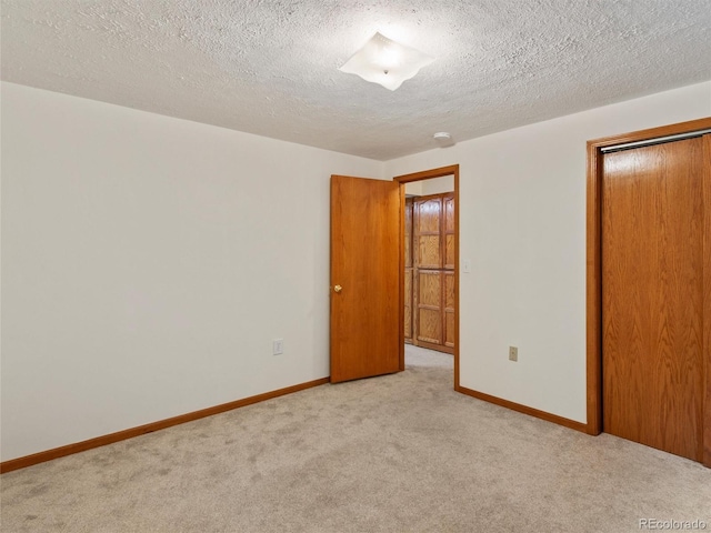 unfurnished bedroom with light carpet, a textured ceiling, and a closet