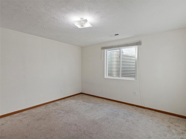 unfurnished room featuring light carpet and a textured ceiling