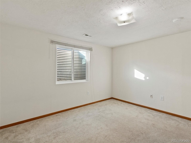 spare room featuring carpet floors and a textured ceiling