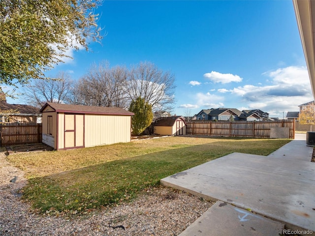 view of yard featuring a patio, central AC, and a storage shed