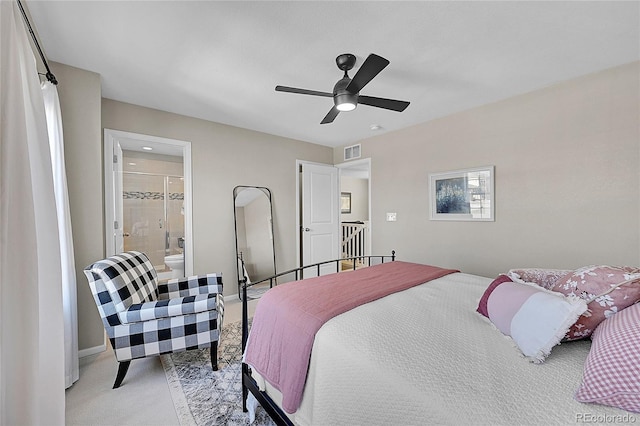 bedroom with ceiling fan, light carpet, and ensuite bath