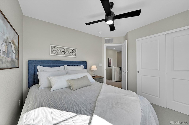 carpeted bedroom with ceiling fan and a closet