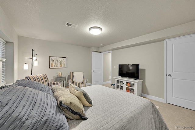 bedroom featuring light colored carpet and a textured ceiling