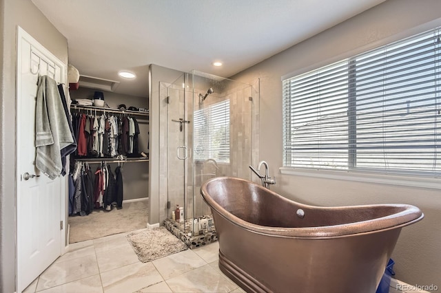 9545 Grand Cypress Cv, Lone Tree, CO 80124 - bathroom featuring tile patterned flooring, a stall shower, a freestanding bath, and a walk in closet
